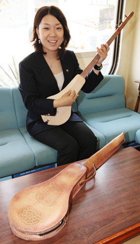 ２年間の任期を終えて帰国した伊藤寛子さん。手にしているのはキルギスの伝統楽器「コムズ」