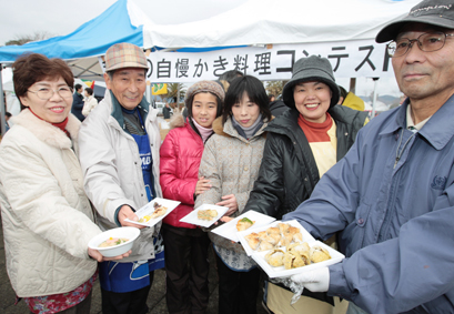 自慢のカキ料理を差し出すコンテスト参加者。左端が優勝した秋岡さん
