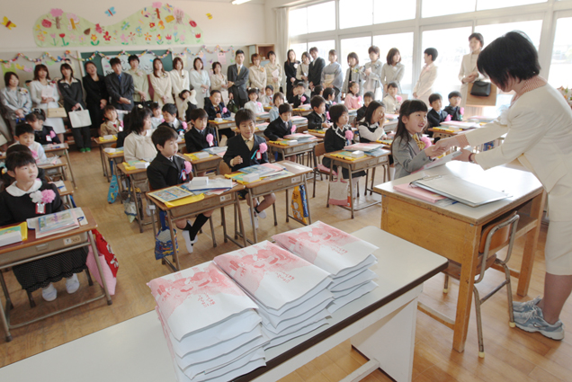 担任の先生から教科書を受け取る新入生