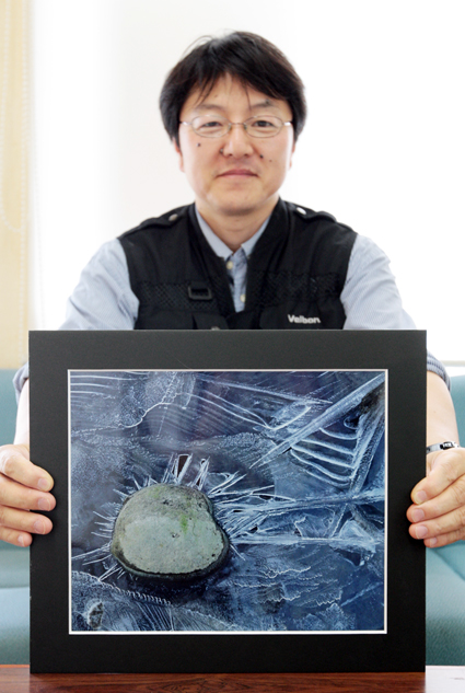 入選作を手に喜びの佐々木英明さん