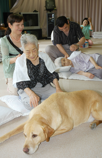 気持ちよさそうにマッサージを受ける利用者のみなさん。手前は盲導犬