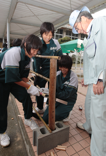 造園教室で体験する生徒たち。出来上がった竹垣は実際に花壇に設置した