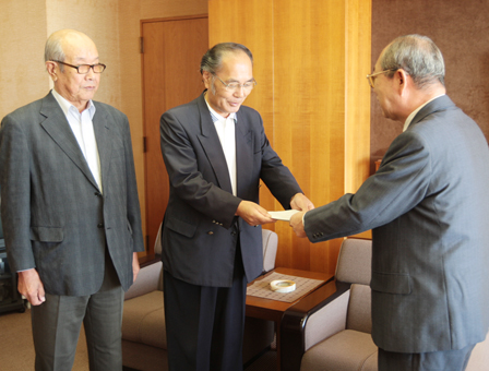 「改定は妥当」との答申書を豆田正明市長に手渡す林頼夫会長(中)