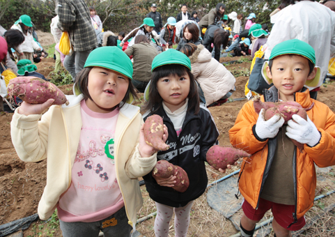 サツマイモを手に笑顔の子どもたち