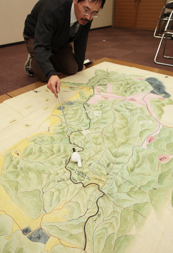 歴史博物館で14日から公開される元禄時代の「争論絵図」。棒で指し示している線が裁定された境界