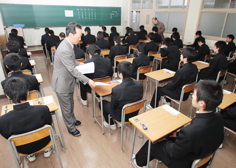 張り詰めた雰囲気の中、問題が配られる高校入試会場