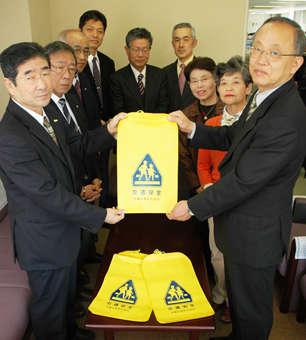 室井久和教育長(右)にランドセルカバーを贈呈する関孝行会長