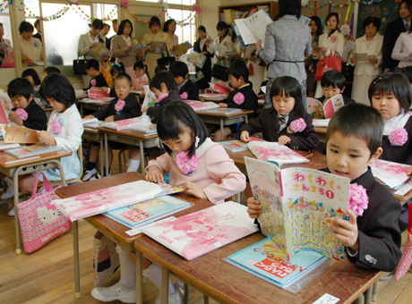 受け取った教科書のページをさっそく開く新入生