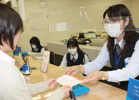 市内の主な金融機関では感染拡大を防ごうと、18日から行員がマスク着用で業務