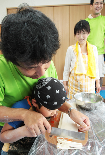 お父さんの大きな手を添えられて手打ちした生地を麺切り