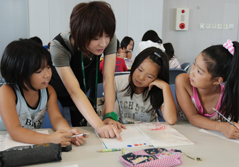 小学生に宿題の進め方をアドバイスする関西福祉大生