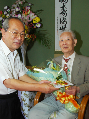 豆田正明市長から祝福を受ける男性最高齢の井藤素一さん