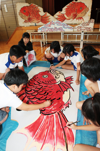 船だんじりの背景画を描く児童たち。奥に見えるのが60年前に使われていた背景画