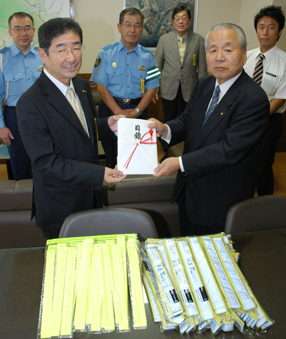 交通安全グッズを寄贈する山本辰一・赤穂ロータリークラブ会長(右)