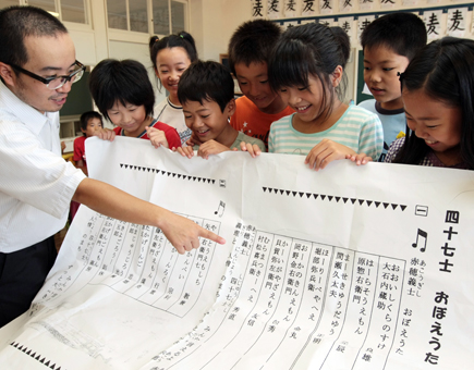 長安健太教諭=左端=が作詞作曲した「四十七士おぼえうた」で義士の名前を覚える子どもたち