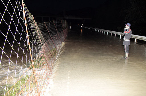 周世・黒谷川からあふれた水で冠水した道路=7月7日午前4時20分、井口博文写す