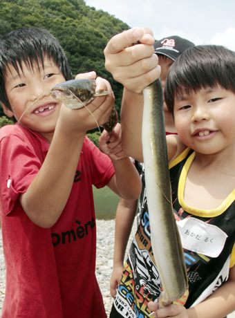 ウナギを掴み取る子どもたち