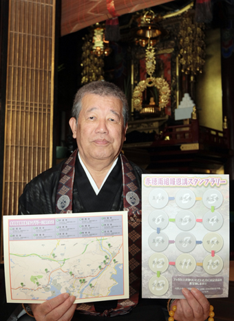 「報恩講スタンプラリー」の台紙を手に参詣を呼び掛ける組長の霜尾孝紹さん