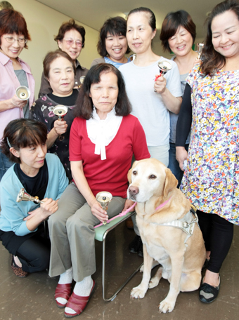 清水さんが代表を務めるハンドベルサークルの仲間に囲まれ、盲導犬としての役目を間もなく終えるトゥルー号