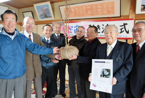 「宇宙桜」の若木を受け取る福浦勇さん=右から2人目