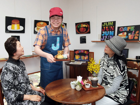 チョークアート展を開催中のギャラリーで来場者を笑顔でもてなす山本淳一郎君