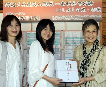 開幕通算5000人目の入館者となった長田彩歩さん=中央=