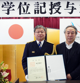 「着衣泳」研究で博士号を取得した木村隆彦さん。右は主指導教員の塩野谷明教授
