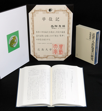 西畑俊昭さんに授与された学位記と著書『近世入浜塩業の研究』