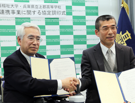 高大連携協定に調印し、握手する関西福祉大学の安井秀作学長(左)と上郡高校の松崎隆幸校長
