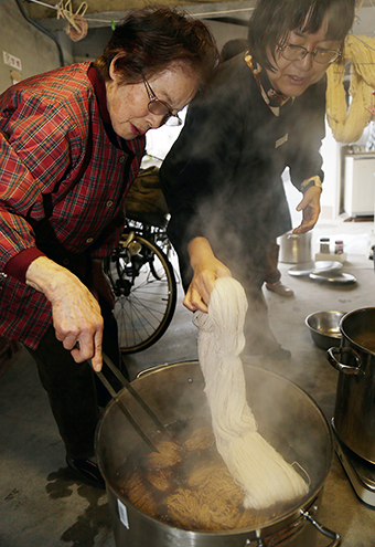 小田中久良子さん(左)の協力で行った染色作業