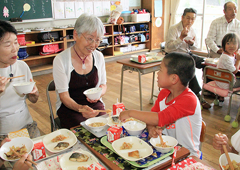児童とお年寄りが和やかに会食した交流給食