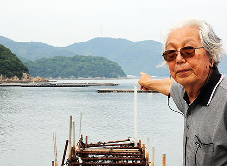 せりあ丸が空襲された位置を指し示す加藤利昭さん。ちょうど指先のあたりに碇泊していたという。指先の左側にあるのが生島。