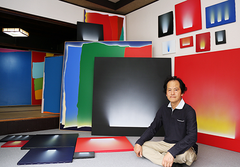 生まれ故郷で個展を開く山本雅也さんと作品の一部