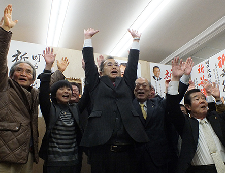 三つどもえの激しい選挙戦を制し、万歳三唱で初当選を祝う明石元秀氏=中央