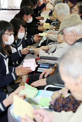 「長生きしてね」などと声を掛けながらメッセージカードを贈る生徒たち