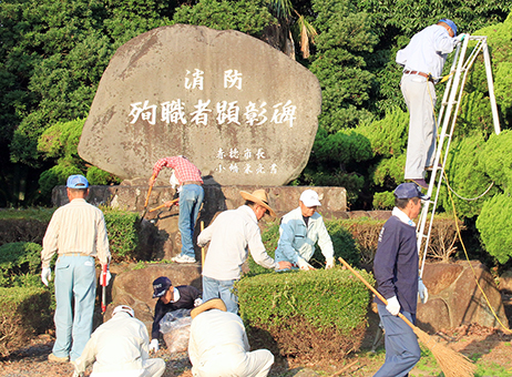「消防殉職者顕彰碑」の周辺を美化清掃する「緋ぐるま会」のみなさん