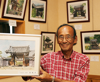 寺院山門のシリーズ絵画展を開いている明石隆之さん