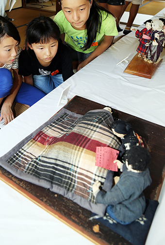 戦時人形展を見学する児童たち