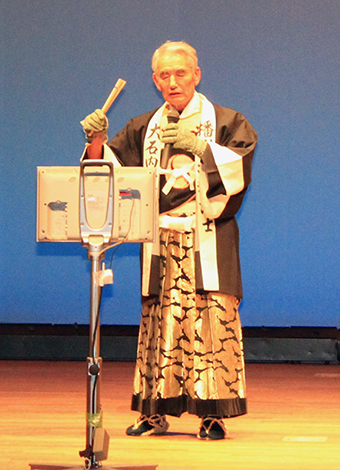大石内蔵助の討ち入り装束で熱唱する川尻篤男さん