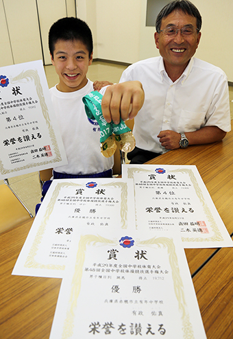 体操の全国中学校選手権で種目別2冠、個人総合4位になり、大田俊也校長から祝福される有政佑真君