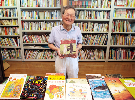 100カ国目の絵本が届いて笑顔の久保良道さん=平成24年6月