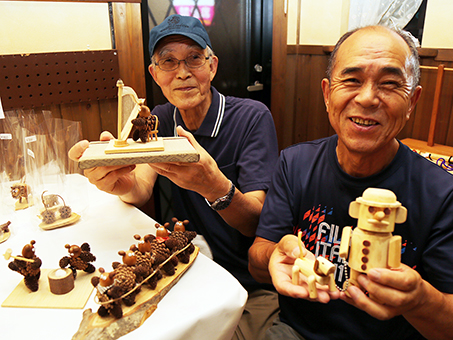 木の実や間伐材を活かした木工クラフト展を開催している岡本隆至さん(右)と安藤収二さん