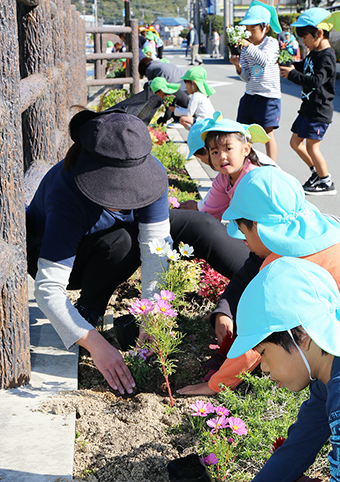 加里屋川沿いの花壇に花苗を植える園児たち