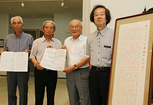 作曲者の古瀬徳雄氏(右)と榊努理事長から楽譜を受贈した萬代新一郎会長と篠原昌三副会長