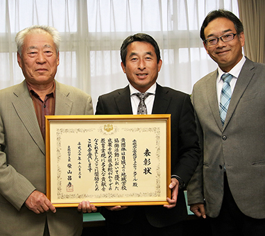 文部科学大臣表彰の喜びを分かち合う=左から=住所知之会長と猪谷公一校長