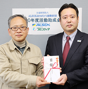 ALSOK姫路支社の原田支社長(右)から活動助成金の目録を受け取る井上理事長