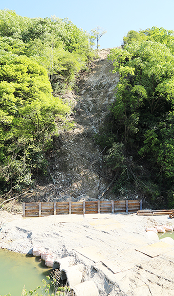 仮設の防護柵が設置された土砂崩れ現場