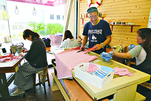 「子どもたちが使ってくれれば」と同僚の協力を得て布マスクを作る三島正嗣さん