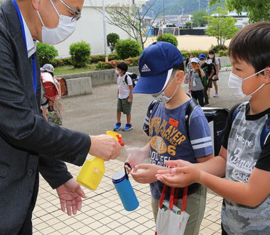 校舎に入る前に手指消毒する児童たち
