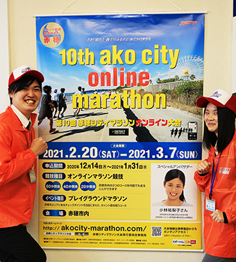 大会PRタペストリーを掲げてエントリーを呼び掛ける大会事務局スタッフ